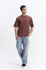 Remera oversize color bordó, de manga corta y escote redondo, con un pequeño estampado en el pecho.