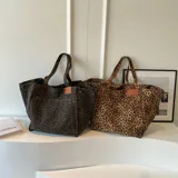 Bolso tote de lona con estampado de leopardo y asas de hombro.