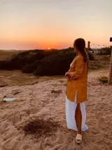 Tapado camel de cuero ovino con cuello clásico, cierre frontal con botones, bolsillos laterales y corte a la rodilla. Diseño slouchy y cómodo.