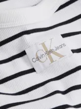 Minivestido blanco con rayas horizontales negras, de corte ajustado y breteles finos blancos.