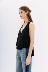 Musculosa blanca de algodón flameado, con escote en V pronunciado y espalda deportiva.