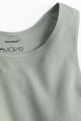 Top deportivo corto color verde claro, de tejido acanalado con tecnología DryMove™ para absorción de humedad. Tiene breteles anchos, copas forradas con relleno extraíble y elástico ancho en el bajo.