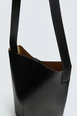 Bolso tipo shopper negro fabricado en piel, con asa de hombro y cierre magnético.