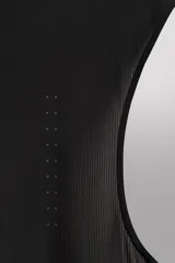Musculosa deportiva negra de tejido ligero y elástico con zonas perforadas para mayor transpirabilidad. Cuello redondo amplio, sisa con acabados termofijados, bajo con aberturas laterales y logo estampado reflectante en la espalda.