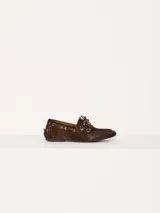 Zapato estilo mocasín acordonado, confeccionado en pelo color marrón con interior forrado en cuero vacuno. Lleva apliques metálicos en níquel.