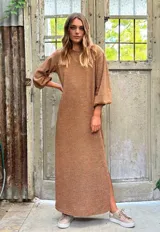 Vestido largo con lurex en tonos tostados, de mangas abullonadas y abertura lateral.