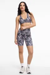Top deportivo con estampado animal print en tonos rosa y negro, con cuello halter y espalda deportiva.