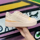 Zapatillas Adidas Forum Bold Her Vegan color beige con detalles en amarillo y suela de plataforma.
