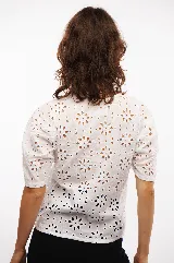 Blusa blanca con mangas cortas abullonadas y bordado calado con motivos florales. Incluye musculosa blanca para usar debajo.