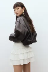Minifalda blanca con lunares dorados, cintura elastizada y tres niveles de volados.