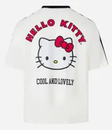 Remera blanca de corte boxy con cuello redondo y detalles en negro. Estampado frontal con logo de Hello Kitty y texto "Sport Club".