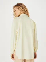 Camisa oversize color amarillo pálido, de manga larga y cuello clásico.
