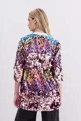 Saco de lentejuelas multicolor con forrería interna y largo a la cadera. Presenta un diseño abierto con mangas tres cuartos y una base de poliéster con forro de viscosa.