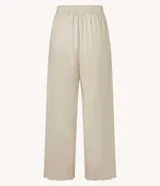 Pantalón recto de cintura alta confeccionado en viscolino color crudo, con elástico en la parte trasera de la cintura, cierre tradicional y textura de palmeras perforadas en el bajo.