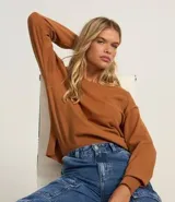 Suéter boxy color marrón, de punto leve, con cuello redondo y mangas largas con puños y bajo acanalados.
