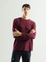 Remera negra de manga larga con cuello redondo, confeccionada en tejido mini piqué de algodón.