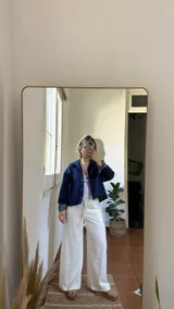 Campera de denim azul oscuro con botones a presión y dos bolsillos frontales.