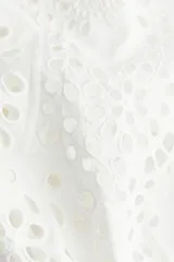 Vestido blanco a la rodilla en tejido liviano de algodón con cuello redondo, botones ocultos adelante y cinturón fino extraíble. Mangas al codo abullonadas en broderie con puños elásticos.