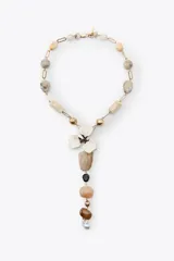 Collar con cadena dorada de eslabones y cuentas de resina en tonos beige y blanco. Dije central con forma de flor esmaltada y colgante con piedras de diferentes tamaños y colores.