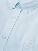 Camisa de hombre color verde oliva, de manga corta y corte clásico. Confeccionada en lino y poliéster, con cuello abotonado y bolsillo en el pecho.