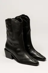 Bota de cuero blanca estilo cowboy con bordados decorativos y taco cubano negro.
