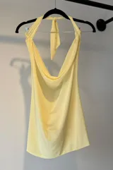 Top amarillo pálido con escote halter y espalda descubierta.