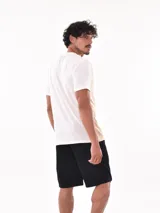Remera negra de corte oversized con bolsillo en el pecho y detalle de bloque gris en el lateral.