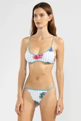 Bombacha de bikini de cobertura mínima con deslizadores laterales ajustables, estampado floral con rayas verticales y terminaciones en color celeste.