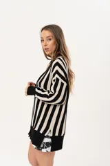 Saco oversize tejido a rayas verticales en blanco y negro, con escote en V y botones.