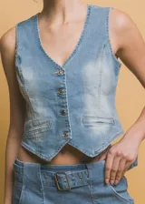 Chaleco de jean celeste con botones metálicos, bolsillos frontales y corte ajustado. Diseño clásico y versátil.