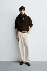 Pantalón de jean color crudo con textura de rayas verticales, corte relaxed fit, tiro medio, cinco bolsillos y cierre frontal con cremallera y botón.