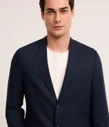 Saco de traje azul marino, confeccionado en viscolino, con cuello en V, cierre por botones, bolsillos y medio forro.