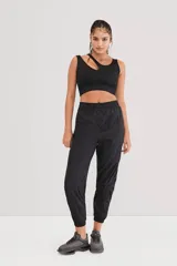 Top deportivo negro asimétrico con un solo tirante ancho y abertura en el pecho.