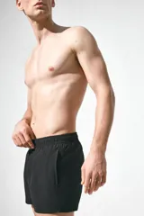 Short de baño negro con elástico revestido y cordón para ajustar oculto en la cintura, bolsillos laterales y abertura corta en los lados. Suspensor interior de malla.