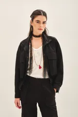 Campera negra con jareta ajustable en el ruedo con cordón de colores, presilla interna en las mangas y bolsillos en el delantero.