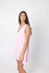 Vestido corto color rosa, de lino, con escote en V y pespuntes a contratono.