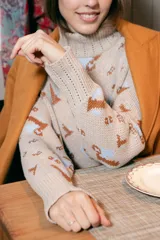 Sweater beige con cuello alto y estampado de anclas en gris.
