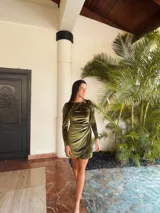 Vestido corto de terciopelo verde oliva, con mangas largas abullonadas y falda cruzada con frunces. Espalda escotada.