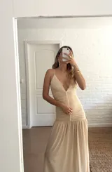 Vestido largo color amarillo pastel, con breteles finos y escote en V. La parte superior es de doble tela de microtul y la falda es amplia con volados.