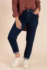 Pantalón jean azul oscuro, corte mom fit, con bolsillos delanteros y traseros, y terminación arremangada.
