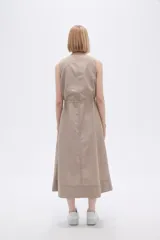 Vestido midi color beige de lino, sin mangas, con escote en V, bolsillos laterales y cordón ajustable en la cintura.