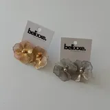 Par de aros colgantes con forma de flor calada, disponibles en plateado y dorado.