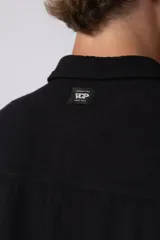 Camisa de lino color blanco, de manga corta, con cuello clásico y cierre frontal con botones.