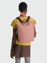 Mochila Longchamp modelo Le Pliage Original M, color rosa con detalles en cuero marrón.
