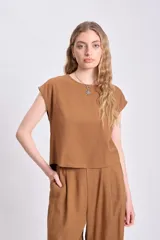 Blusa casual color tostado, confeccionada en lino, sin mangas y de corte holgado.