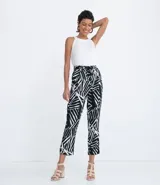 Pantalón pijama fluido de viscosa con estampa geométrica en blanco y negro. Tiene cintura media con ajuste de cordón con puntera metálica, bolsillos y prega frontal.