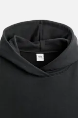 Sudadera negra corta con capucha, manga larga, bolsillo tipo canguro y terminaciones en rib.