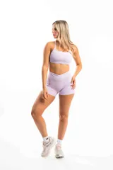 Top deportivo color lila con tirantes finos y espalda cruzada.