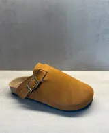 Sueco tipo clog color camel, con capellada de material gamuzado y hebilla metálica ajustable en el lateral. Presenta una plantilla anatómica de corcho y suela de goma oscura.
