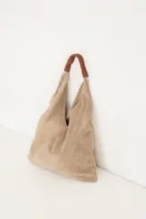 Bolso tipo tote bag color beige de cuero gamuzado, con doble asa de cuero marrón.